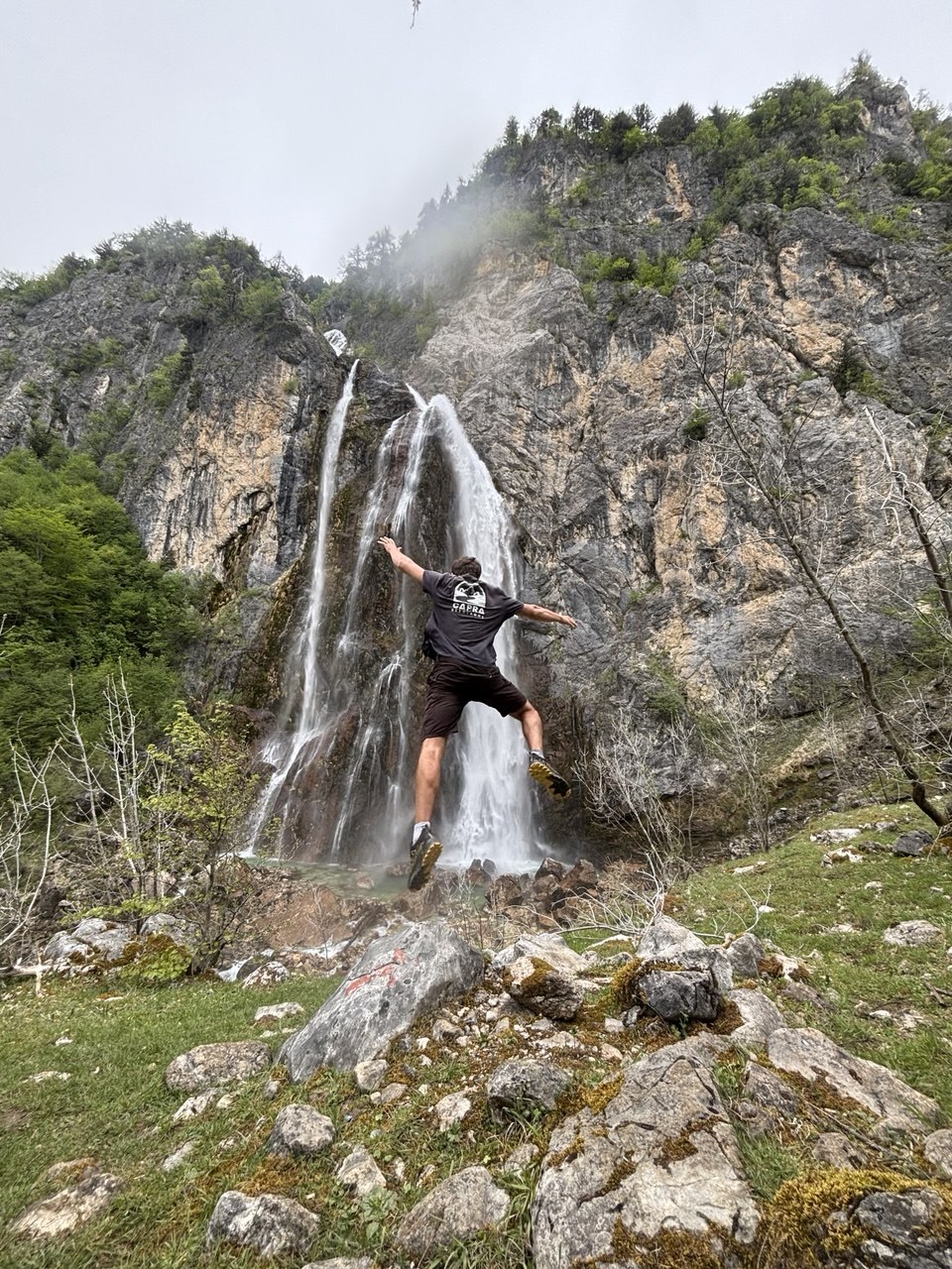 Elmo saltando frente a una cascada